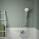 Brausearmatur in Chrom von Ideal Standard, installiert an einer Wand mit grüner Farbe, daneben ein weißes Handtuchregal und ein grünes Handtuch.